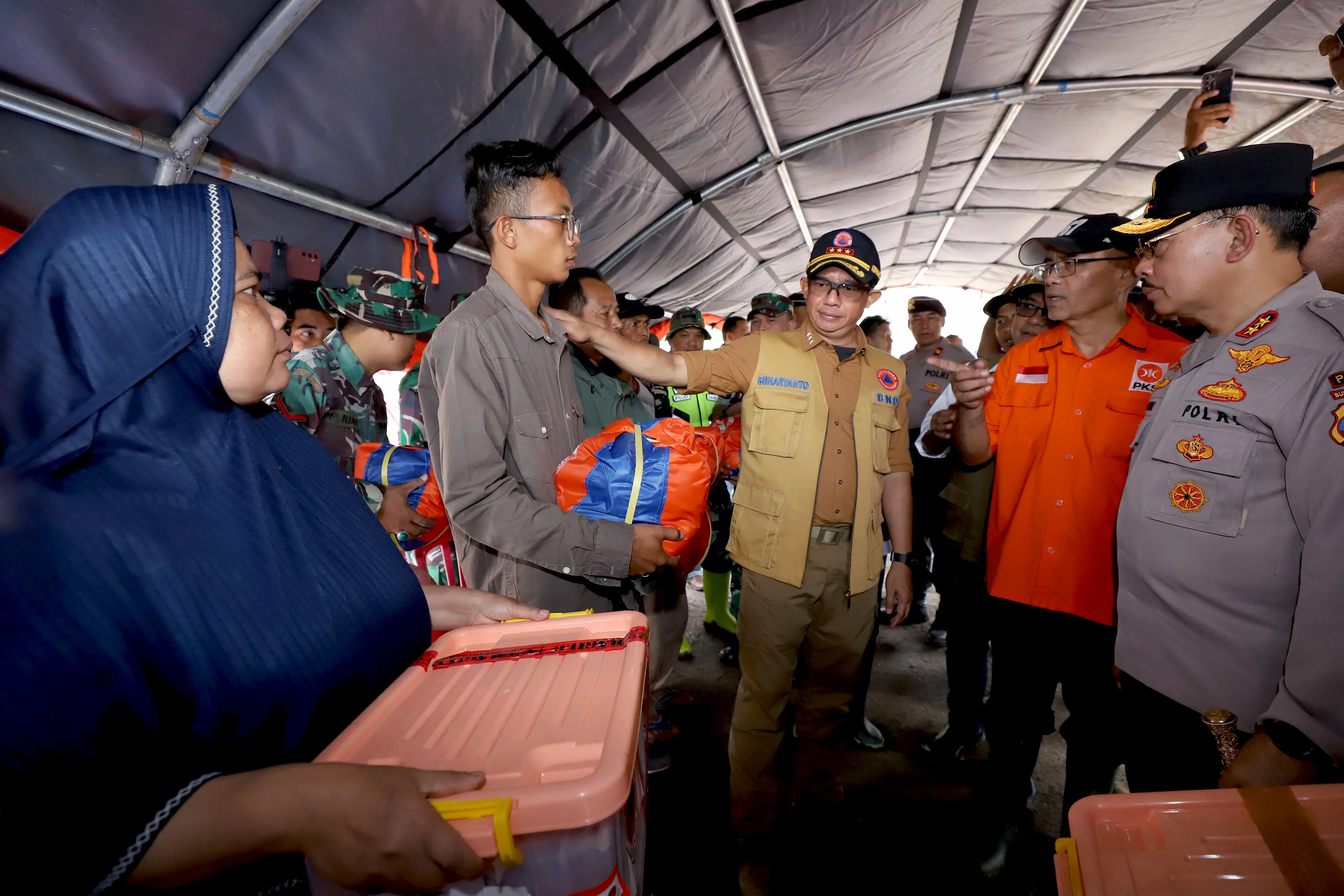 Kepala BNPB Letjen TNI Suharyanto (kemeja dan rompi cokelat) memberikan bantuan secara simbolis kepada warga terdampak banjir lahar hujan dan tanah longsor yang melanda wilayah Pandai Sikek, Kabupaten Tanah Datar, Sumatra Barat, pada Selasa (14/5).